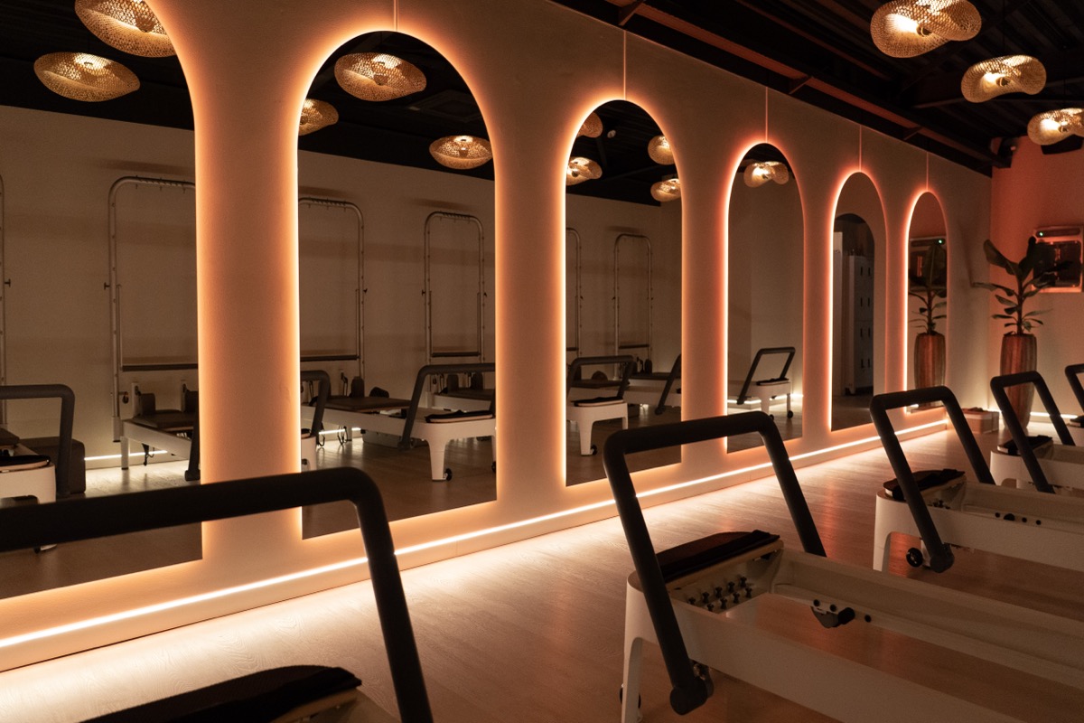 Refined Movement studio in Soest met iconische verlichte boogspiegels in avondsfeer